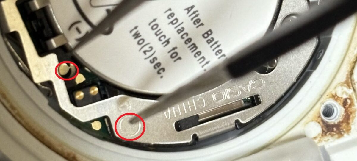 G-SHOCKのACショート箇所をピンセットで押さえている